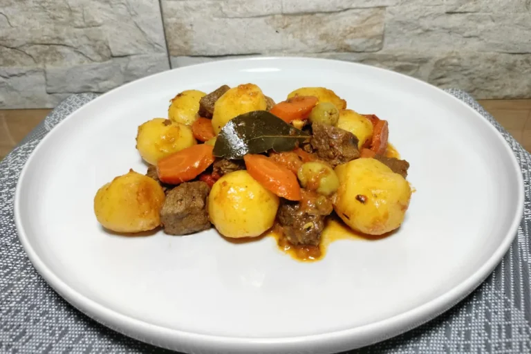 Un plato con carne con papas canaria.