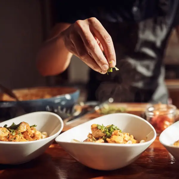 Un cocinero añade perejil picado para finalizar con la presentación de una receta