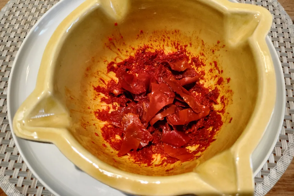 Pimienta picona troceada en un mortero para hacer mojo rojo canario.