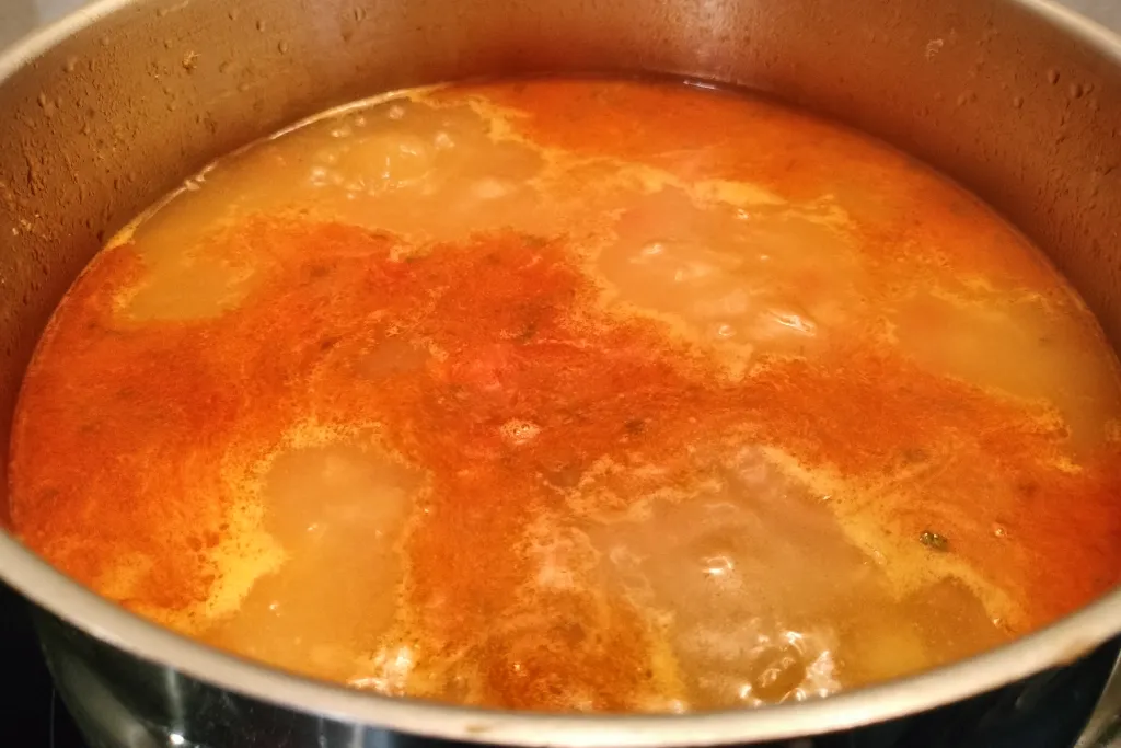 Sofrito recién añadido al caldo para hacer un rancho canario.