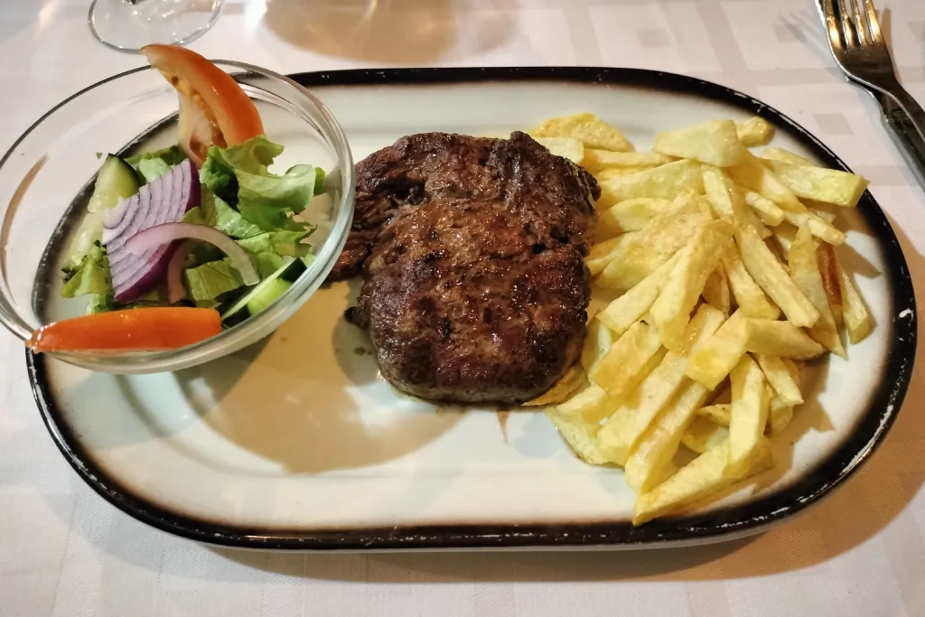 Un solomillo de res a la plancha con papas fritas y ensalada como segundo plato