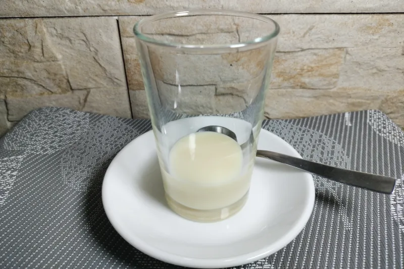 Un vaso con la primera capa de leche condensada para hacer un barraquito
